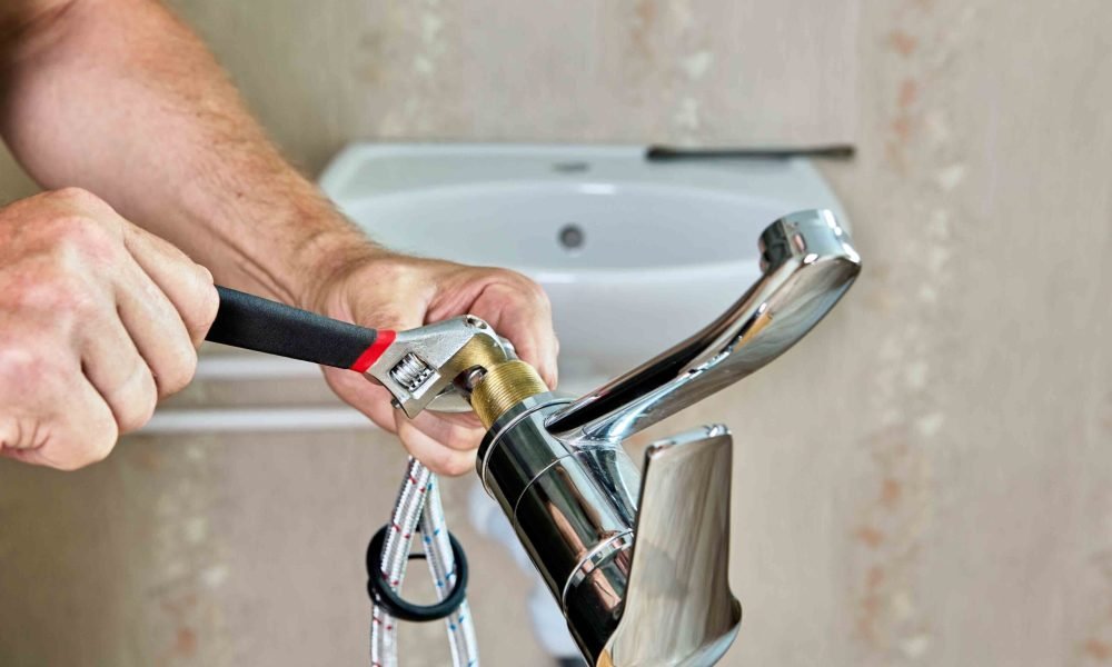 Repair work in bathroom, plumber installing new tap in home water supply system.